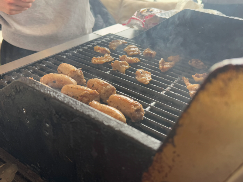 グリルで焼かれるソーセージと肉